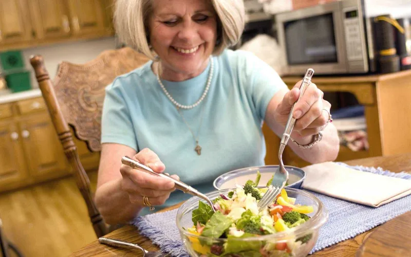 foto di donna che sta condendo l'insalata