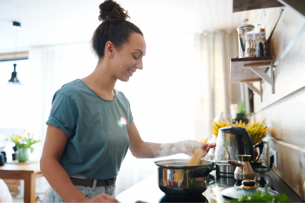 foto di una ragazza che cucina della pasta