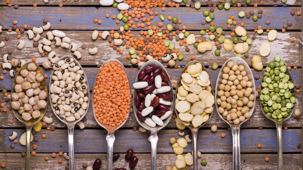 Tavolo con cucchiai pieni di proteine alimentari: i legumi